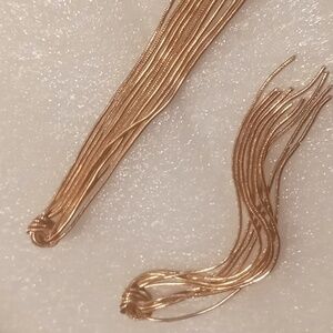 Knotted tassel snake chain earrings .